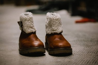 Koyun postu kürklü eski deri çizmeler, çocuklar için kışın izole edilmiş ayakkabılar. Retro ayakkabılar. Bir ikinci el mağazasında yün süslemeli çizme ya da evsizler ve mülteciler için insani yardım mağazası.
