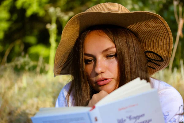 Όμορφη Μελαμψό Μαυρισμένη Νεαρή Γυναίκα Ψάθινο Καπέλο Διαβάζει Ένα Βιβλίο — Φωτογραφία Αρχείου