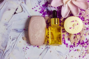 Masaya saçılmış lavanta kokulu deniz tuzu kristalleri, sabun barları, yüz şişeleri, vücut bakımı yağı, kozmetik serumu. Kozmetik yatıyordu. Güzellik günü. Güzel kompozisyon üst görünüm düz.