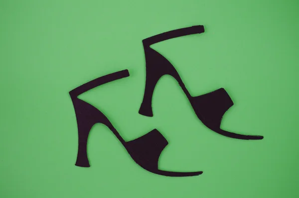 Papierschnitt aus Damensandalen auf grünem Hintergrund — Stockfoto