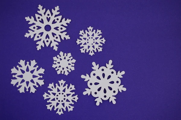 Snowflake cut outs on blue purple background — Stock Photo, Image
