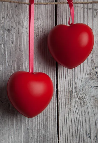 Два серця на червоній стрічці висять на лінії одягу — стокове фото