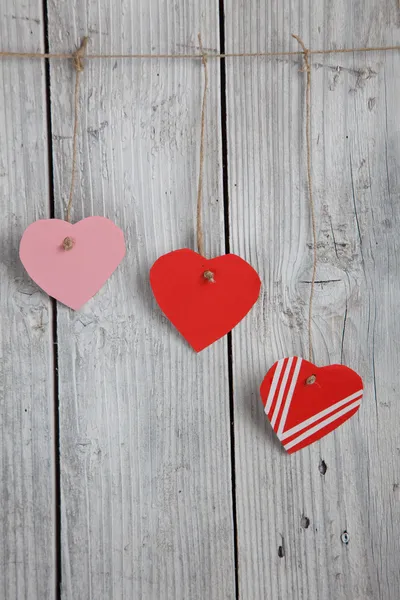 Tres corazones de papel colgando de un tendedero — Foto de Stock