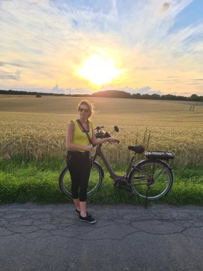 Yazlık şehir parkında bisiklet süren genç bir kadın. Aktif insanlar. Hippi kız rahatla ve bisiklete bin. Yaz günü işe bisikletle gitmek. Bisiklet ve ekoloji yaşam tarzı kavramı