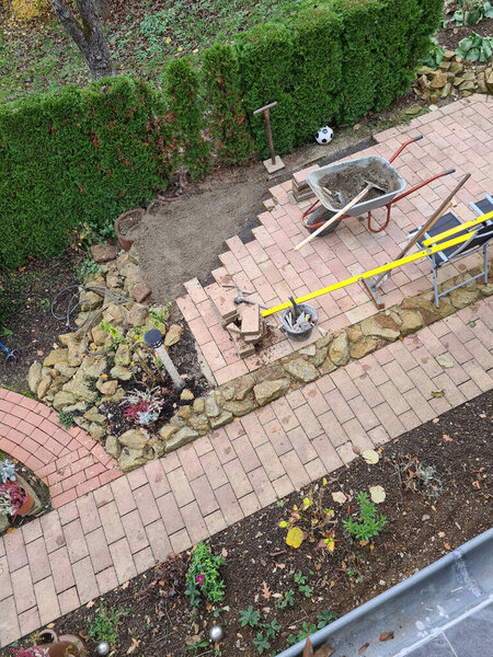 Рабочий кладет камни на тротуар