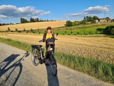 Güneşli bir yaz gününde güneşli bir yaz gününde bir parkta bir cep telefonu kullanarak bir genç kız profili saçlarını hareket ettiren rüzgar ile