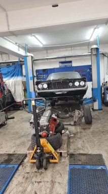 Araba atölyesi, siyah klasik araba kaldırma platformunda