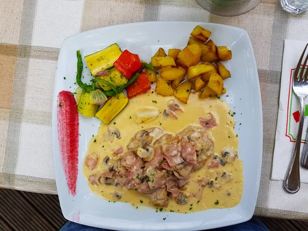 Kızarmış patates ve soslu şnitzel. 