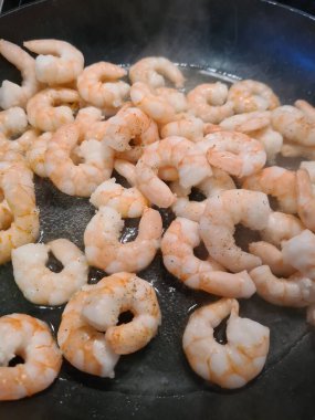 Tereyağı ve bitkilerle tavada kızartılmış sıcak karides.