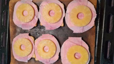 Hawaii usulü kızarmış ekmek, jambon, peynir ve ananaslı siyah arka planda, yatay kesim tahtası. 