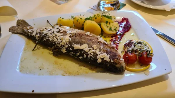 Kızarmış gökkuşağı alabalığı, kırmızı biber, biberiye ve patates. 