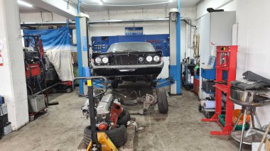 Araba atölyesi, siyah klasik araba kaldırma platformunda