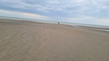 Zelande Limanı 'nın manzarası ve gölün çevresi ve kısmen mavi gökyüzünün altındaki kum tepeleri.