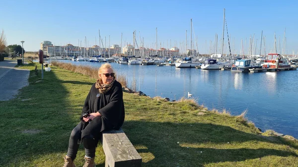 Portrait Blonde Woman Wearing Sunglasses Sitting Bench Marina Boats Background — Stockfoto