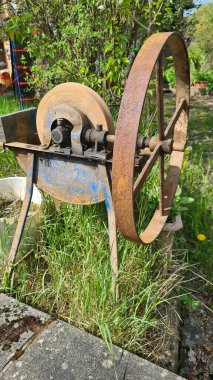 Köy evinin bahçesinde eski öğütücü bileme taşından el tekerleği.