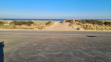 Zelande Limanı 'nın manzarası ve gölün çevresi ve kısmen mavi gökyüzünün altındaki kum tepeleri.