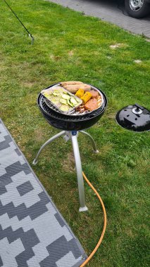 Barbecue at the campground at summer camp trips, skewers of pork and beef tenderloin at barbecue party in camping, summer camp trips an activity to relax.