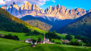 Val di Funes 'deki Santa Magdalena köyü İtalyan Dolomitleri üzerinde. Arka planında renkli ağaçlar ve Odle Dağı grubu olan vadinin sonbahar manzarası. İtalya