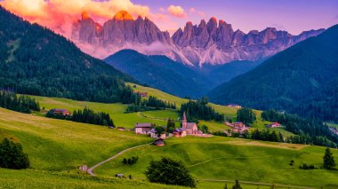 Val di Funes 'deki Santa Magdalena köyü İtalyan Dolomitleri üzerinde. Arka planında renkli ağaçlar ve Odle Dağı grubu olan vadinin sonbahar manzarası. İtalya