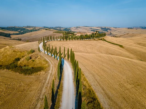 Toscane landschap met graanvelden, cipressen en huizen op de heuvels bij zonsondergang. Zomer landelijk landschap met gebogen weg in Toscane, Italië, Europa, Italië, Agriturismo Baccoleno — Stockfoto