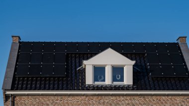 Güneşli bir gökyüzüne bağlı güneş panelleri olan yeni evler inşa edin. Siyah güneş panelleri olan yeni binaları kapatın. Zonnepanelen, Zonne enerjisi, Çevirisi: Güneş paneli, Güneş Enerjisi