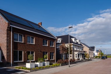 Güneşli bir gökyüzüne bağlı güneş panelleri olan yeni evler inşa edin. Siyah güneş panelleri olan yeni binaları kapatın. Zonnepanelen, Zonne enerjisi, Çevirisi: Güneş paneli, Güneş Enerjisi