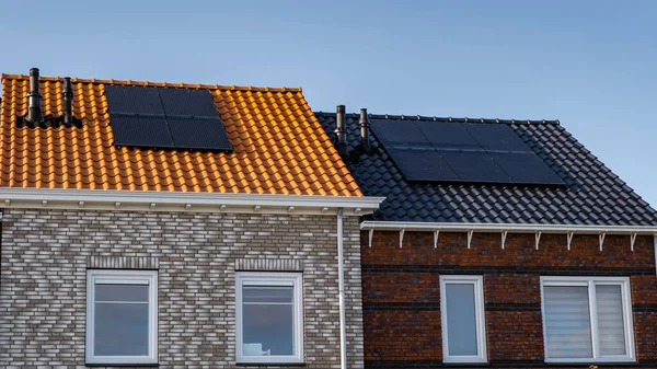 Nybyggda hus med solpaneler fästa på taket mot en solig himmel Närbild av ny byggnad med svarta solpaneler. Zonnepanelen, Zonne energie, Översättning: Solpanel,, Sun Energy — Stockfoto