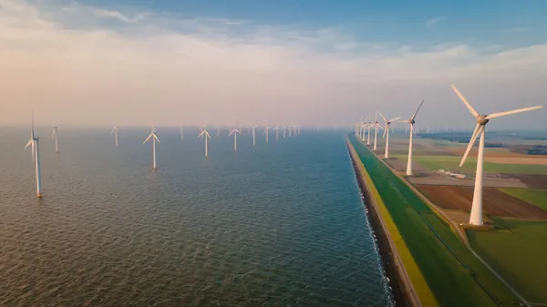 Ветряные мельницы для производства электроэнергии Нидерланды Flevoland, ветряные турбины фермы в море, ветряные мельницы фермы по производству зеленой энергии. Нидерланды — стоковое фото