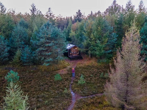 Dřevěná chata v podzimním lese v Holandsku, srub mimo mřížku, dřevěná chata obklopená barevnými žlutými a červenými podzimními stromy — Stock fotografie