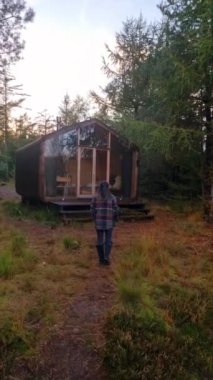 Orta yaşlı bir kadın, Hollanda 'da sonbahar mevsiminde Drentsche Aa' da turuncu kırmızı ağaçlarla doğa yürüyüşü yaparak ormanda yürüyor.