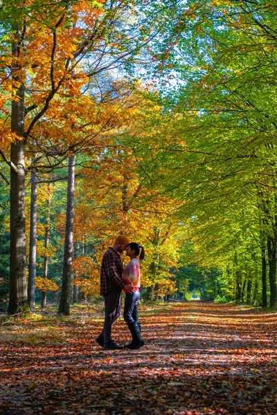 Pareja hombre y mujer mediana edad caminando en el bosque durante la temporada de otoño en la naturaleza trekking con árboles de color rojo anaranjado durante la temporada de otoño en los Países Bajos Drentsche Aa — Foto de Stock