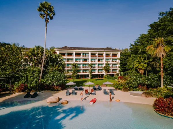 Lüks otel yüzme havuzu, güzel tropik plaj ve deniz şemsiyeli ve sandalyeli otel havuzunda seyahat ve tatil için yüzme havuzu.