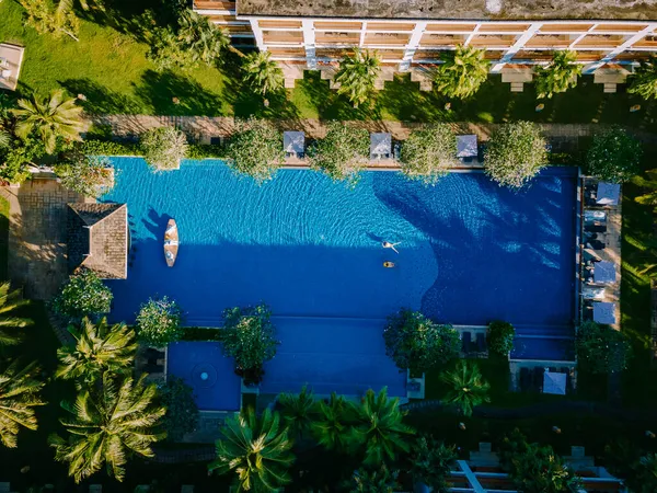 Piscina de lujo, Hermosa playa tropical y mar con sombrilla y silla alrededor de la piscina en el complejo hotelero para viajes y vacaciones —  Fotos de Stock