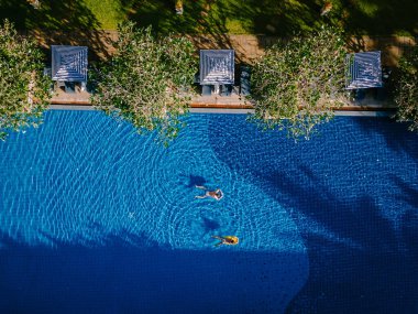 Lüks otel yüzme havuzu, güzel tropik plaj ve deniz şemsiyeli ve sandalyeli otel havuzunda seyahat ve tatil için yüzme havuzu.