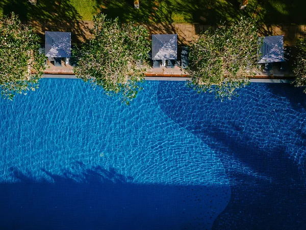 Lüks otel yüzme havuzu, güzel tropik plaj ve deniz şemsiyeli ve sandalyeli otel havuzunda seyahat ve tatil için yüzme havuzu. — Stok fotoğraf