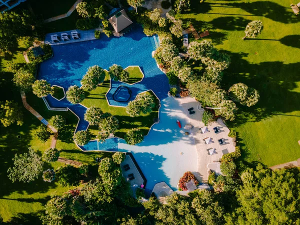 Piscina de lujo, Hermosa playa tropical y mar con sombrilla y silla alrededor de la piscina en el complejo hotelero para viajes y vacaciones —  Fotos de Stock