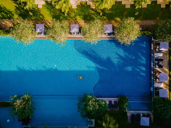 高級ホテルスイミングプール、旅行や休暇のためのホテルリゾート内のプールの周りの傘と椅子と美しい熱帯のビーチと海 — ストック写真