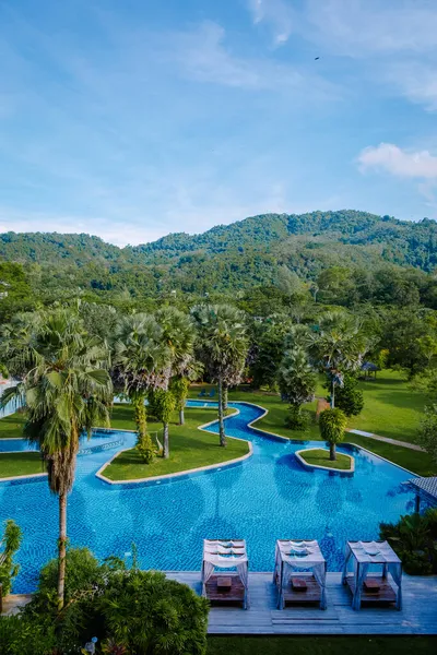 Kolam renang hotel mewah, pantai tropis yang indah dan laut dengan payung dan kursi di sekitar kolam renang di resor hotel untuk perjalanan dan liburan — Stok Foto