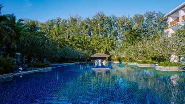 Lüks otel yüzme havuzu, güzel tropik plaj ve deniz şemsiyeli ve sandalyeli otel havuzunda seyahat ve tatil için yüzme havuzu. — Stok fotoğraf