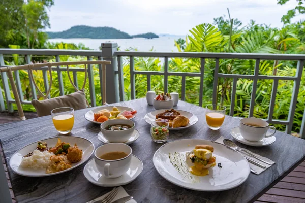海を見下ろす朝食テーブル、コーヒーパンのクロワッサンとフルーツプラッタと朝食。 — ストック写真
