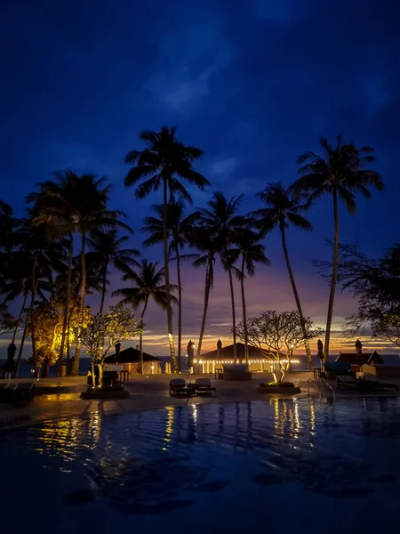 Piscina de luxo com palmeiras à noite durante o pôr do sol na Tailândia — Fotografia de Stock