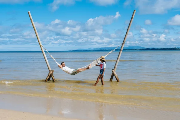 Χαλάρωση σε μια αιώρα στην παραλία στο Πουκέτ της Ταϊλάνδης, ζευγάρι άντρας και γυναίκα διακοπές πολυτελείας στην Ταϊλάνδη — Φωτογραφία Αρχείου