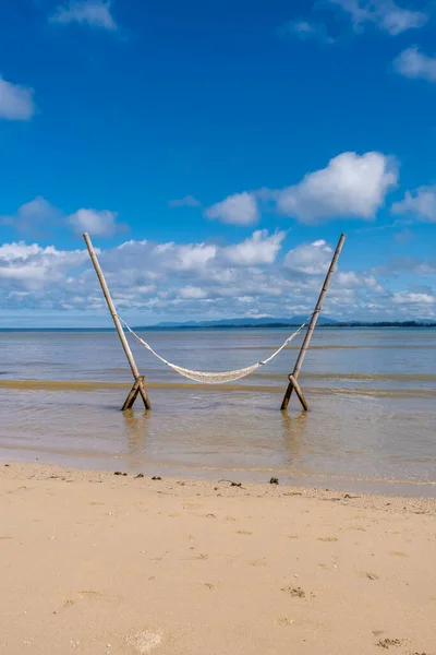 Relaxante em uma rede na praia em Phuket Tailândia, homem e mulher casal e umas férias de luxo na Tailândia — Fotografia de Stock