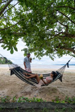 Phuket Tayland 'da bir hamakta dinlenen çift, Tayland' da lüks bir tatil yapıyor.