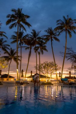Tayland 'da gün batımında palmiye ağaçlarıyla dolu lüks yüzme havuzu