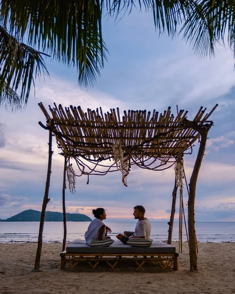 Tramonto sulla spiaggia di Phuket Thailandia, uomo e donna di mezza età in vacanza in Thailandia Phuket, uomo e ragazza asiatica sulla sedia a sdraio sulla spiaggia di Phuket — Foto Stock