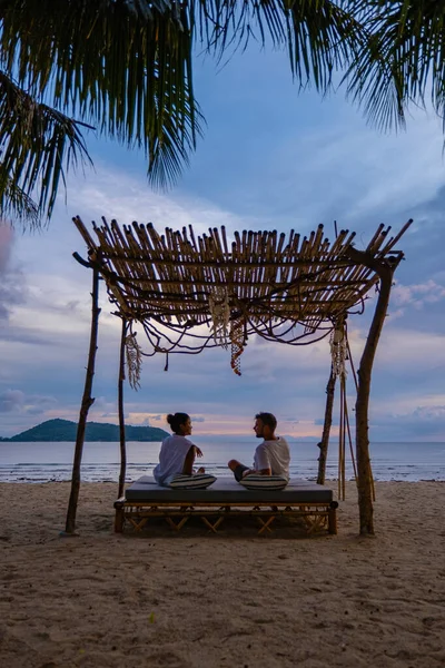 Tramonto sulla spiaggia di Phuket Thailandia, uomo e donna di mezza età in vacanza in Thailandia Phuket, uomo e ragazza asiatica sulla sedia a sdraio sulla spiaggia di Phuket — Foto Stock