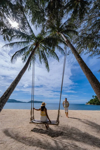 Plajdaki çift Puket 'te plaj sandalyesinde dinleniyor, Phuket Tayland' daki tropikal plajda.