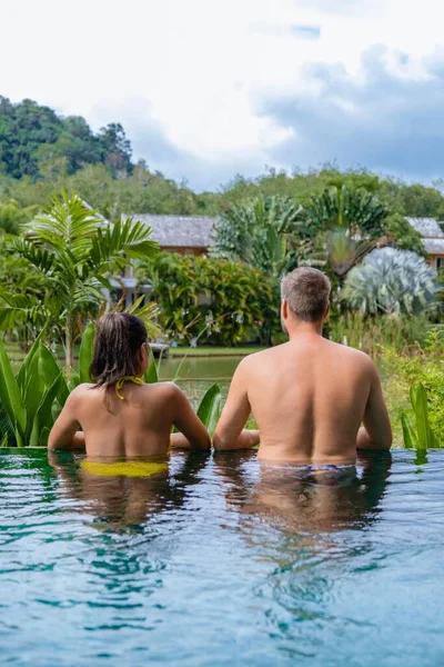 Coppia uomo e donna in piscina in Asia, uomini e donne asiatiche in piscina in Thailandia vicino al lago in montagna — Foto Stock