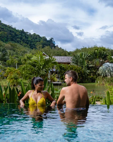 Pareja hombre y mujer en la piscina en Asia, hombres y mujer asiática en la piscina en Tailandia junto al lago en las montañas — Foto de Stock